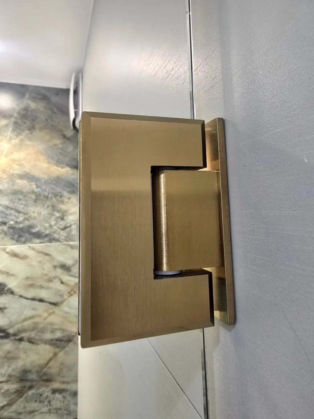 Detalj: zlatna šarka staklo-zid